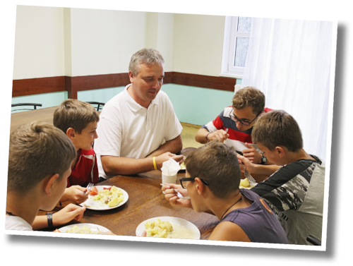 Rahmen_Pater Chaban mit Jugendlichen beim Essen Rahmen_Pater Chaban mit Jugendlichen beim Essen